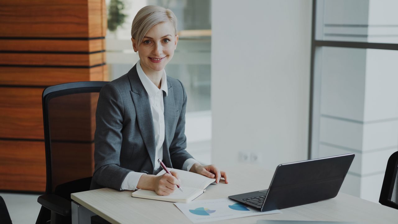 Crafting Captivating Headlines: Your awesome post title goes here Confident businesswoman taking notes in a contemporary office environment.